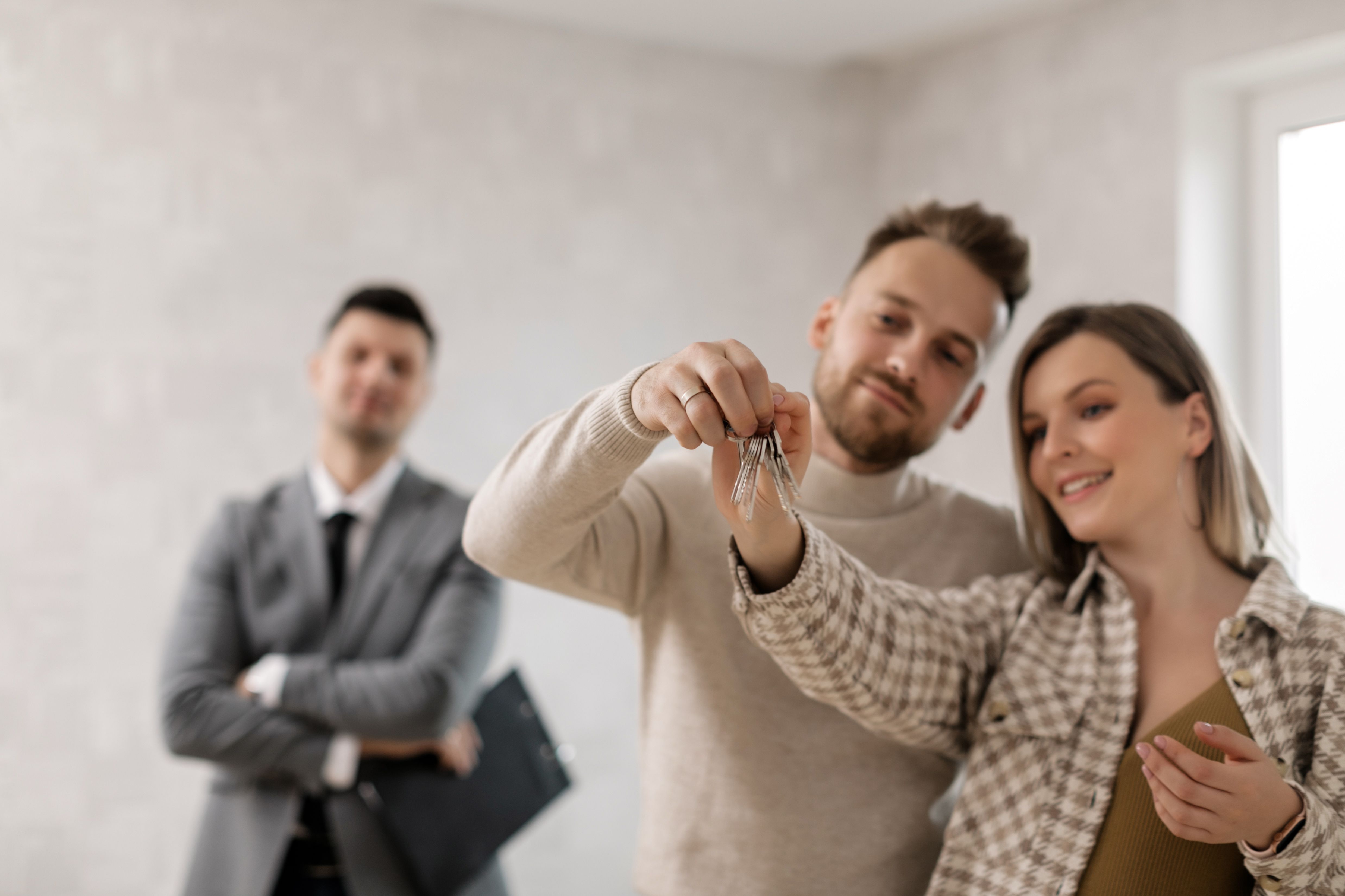 Tenants%20happily%20hold%20the%20keys%20to%20their%20new%20rental%20while%20the%20property%20manager%20stands%20in%20the%20background Tenants happily hold the keys to their new rental while the property manager stands in the background